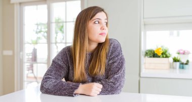 Güzel genç kadın evde doğal yüz emin gülümseme ile pozuyla profil rahatla tarafına, seyir.