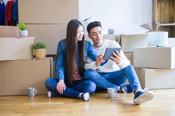 Jovem casal asiático sentado no chão do novo apartamento arround — Fotografia de Stock