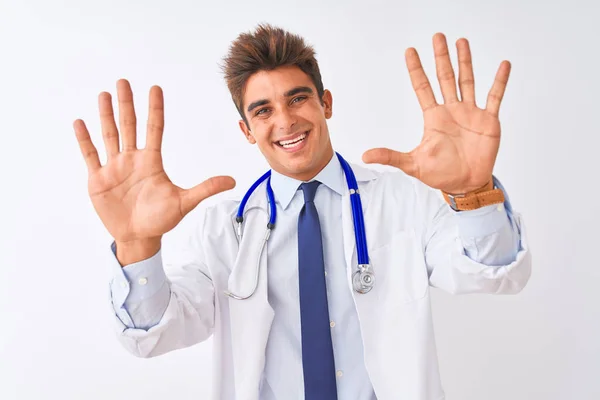 年轻的英俊的医生男子穿着听诊器在孤立的白色背景显示和指着手指数字十 同时微笑自信和快乐 — 图库照片