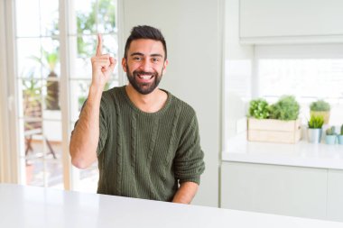 Yakışıklı adam silah ve parmaklar ile işaret, yüzünde büyük bir gülümseme ile neşeli gülümseyen