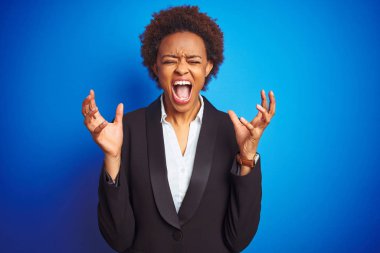 İzole mavi arka plan üzerinde Afrika Amerikan iş icra kadın çılgın ve silah ile başarı için deli kutluyor kaldırdı ve heyecanlı çığlık kapalı gözleri. Kazanan kavramı