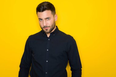 Genç yakışıklı adam possing ve modelleme sarı izole bac üzerinde