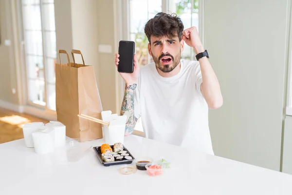 Joven Comiendo Sushi Asiático Entrega Domicilio Mostrando Pantalla Del Teléfono — Foto de Stock