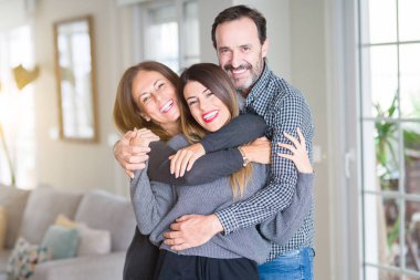 Güzel aile birlikte. Anne, baba ve kızı gülümseyen ve evde sevgi ile sarılma.
