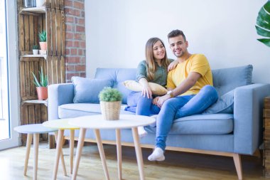 Evde kanepede aşık genç güzel çift oturan