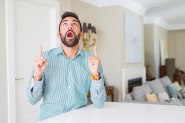 Evde yakışıklı İspanyol hayret ve yukarıya bakıp parmakları ile işaret şaşırttı ve silah kaldırdı.