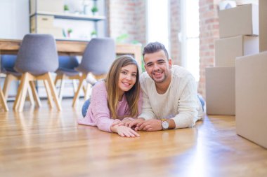 Aşk genç güzel çift yeni bir eve hareket, karton kutular etrafında yerde yatıyor, yeni daire için çok mutlu ve neşeli