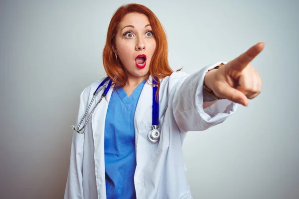 Joven Doctora Pelirroja Usando Estetoscopio Sobre Fondo Blanco Aislado Señalando —  Fotos de Stock