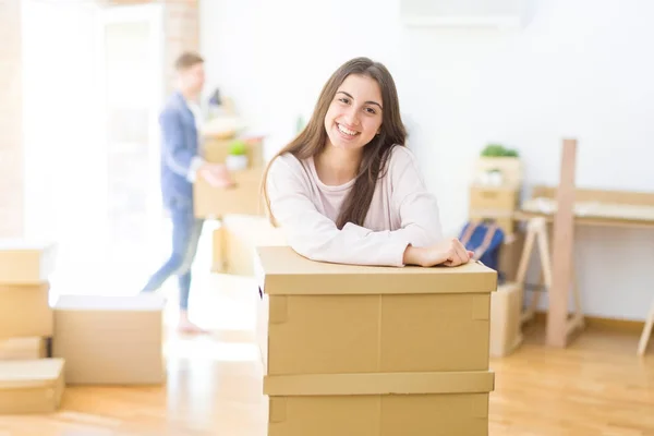 Beautiful young couple moving to a new home, young woman smiling — Stock Photo, Image