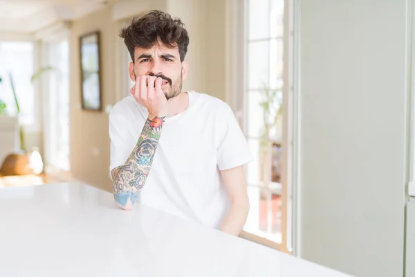 Hombre Joven Con Camiseta Casual Sentado Mesa Blanca Mirando Estresado — Foto de Stock