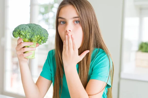 美丽的年轻女孩吃新鲜的花椰菜覆盖嘴与手震惊的错误 表达恐惧 在沉默中害怕 秘密的概念 — 图库照片