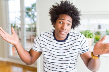 Şeritler tişört giyen Afrikalı Amerikalı adam clueless ve kollar ve elleri ile karıştı ifade kaldırdı. Şüphe kavramı.