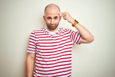 Sakal ile genç kel adam rahat çizgili kırmızı t-shirt beyaz izole arka plan üzerine alnında sivilce için mutsuz işaret, siyah kafa çirkin enfeksiyon. Akne ve cilt sorunu