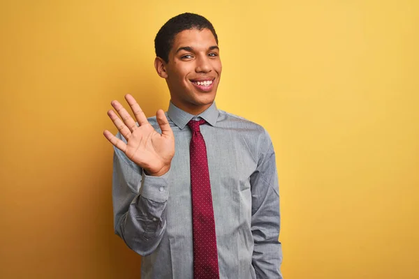 シャツを着て 孤立した黄色の背景の上にネクタイを着ている若いハンサムなアラブのビジネスマンは 自信を持って幸せに微笑みながら 指番号5を示し 指を上げる — ストック写真