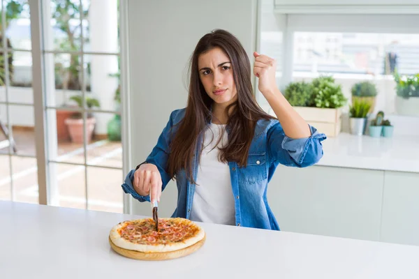 Piękna Młoda Kobieta Cięcie Smaczne Kawałek Pizzy Pomocą Noża Zirytowany — Zdjęcie stockowe