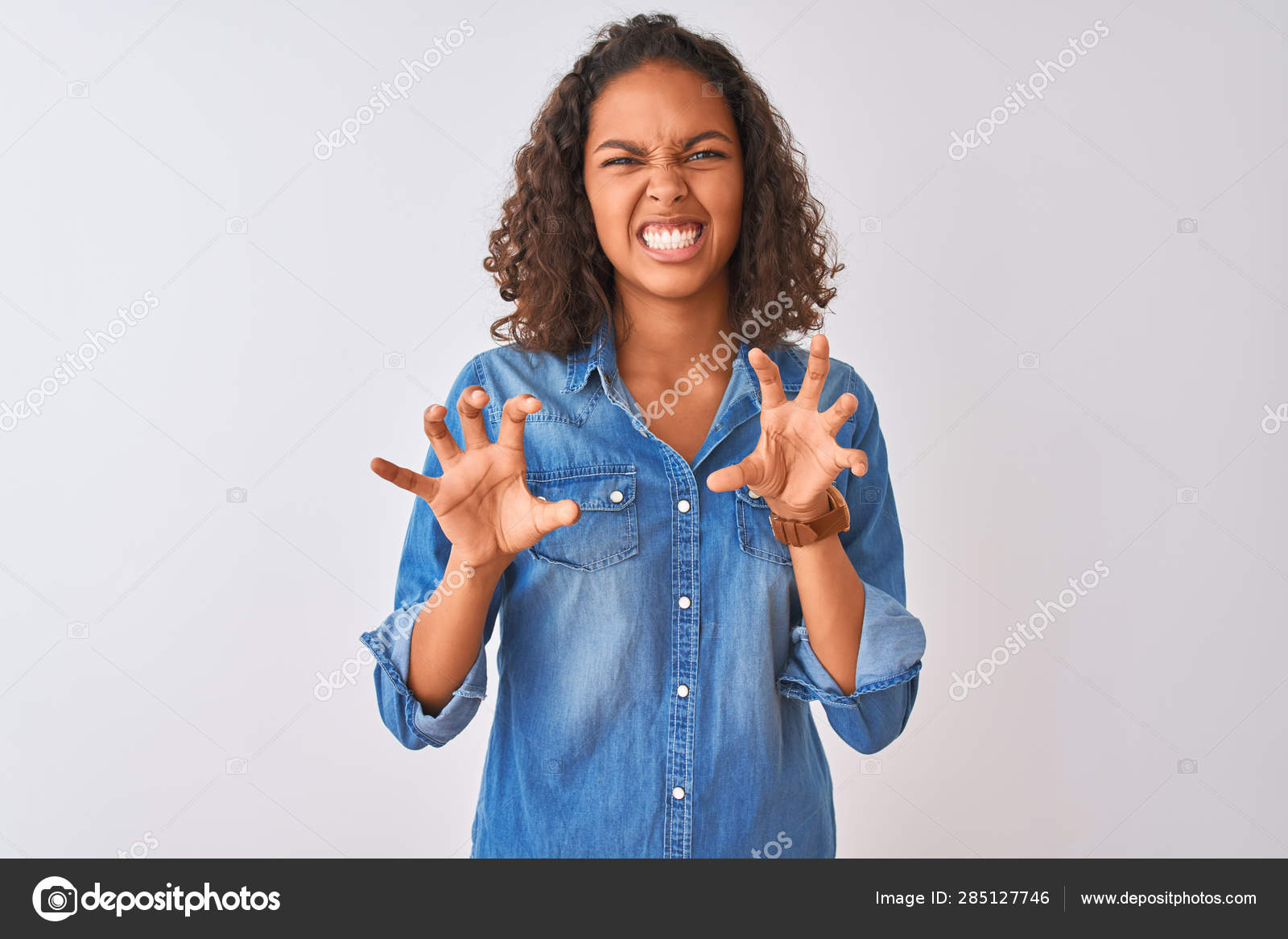 孤立した白い背景の上に立つデニムシャツを着た若いブラジル人女性は 猫のように爪のジェスチャーをやって面白い笑顔 攻撃的でセクシーな表情 ストック写真 C Krakenimages Com