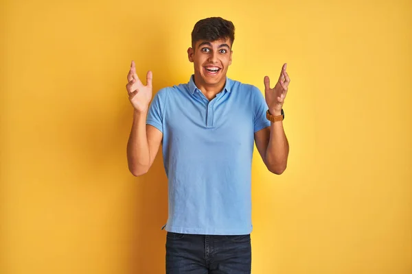 Homem Indiano Jovem Vestindo Pólo Azul Sobre Fundo Amarelo Isolado — Fotografia de Stock