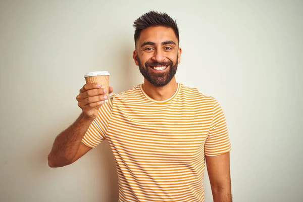 Young indian man drinking cup of coffee standing over isolated white background with a happy face standing and smiling with a confident smile showing teeth