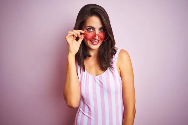 Schöne Frau Gestreiftem Rosa Badeanzug Und Herzförmiger Sonnenbrille Über Rosa — Stockfoto