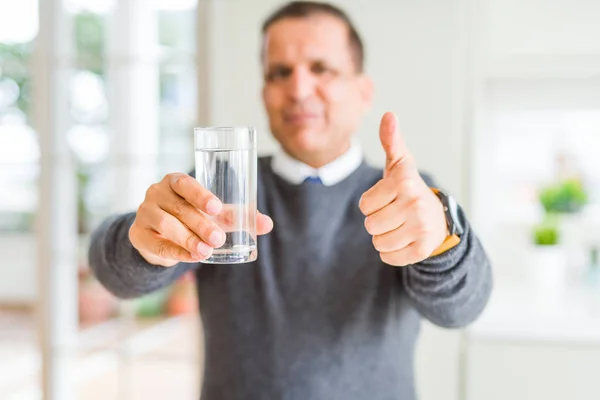 自宅で水のコップを飲む中年男性は Okサインをやって大きな笑顔で幸せ 指で親指アップ 優れた兆候 — ストック写真