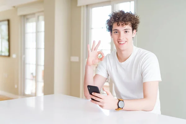 Hombre Joven Usando Teléfono Inteligente Casa Haciendo Signo Con Los — Foto de Stock