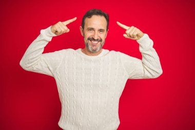 İki el parmak, büyük bir fikir veya düşünce, iyi bellek ile kafa işaret gülümseyen izole kırmızı arka plan üzerinde gri saçlı yakışıklı orta yaş kıdemli adam