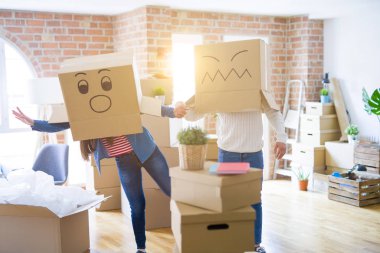 Çılgın çift kafa üzerinde komik yüzler ile kutuları giyiyor, yeni bir eve taşımak için mutlu eğlenceli