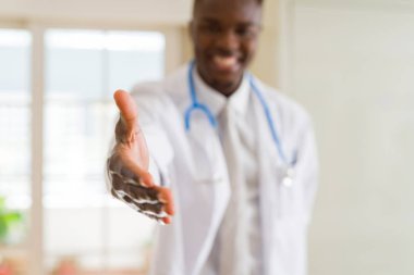 Bir Afrikalı doktor el hoş geldiniz el sallamak ve gülümseyen sunan yakın çekim