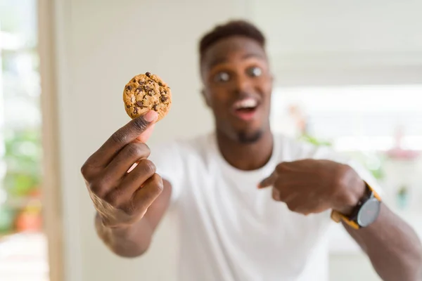 Joven Afroamericano Hombre Comiendo Galletas Chips Chocolate Con Cara Sorpresa — Foto de Stock