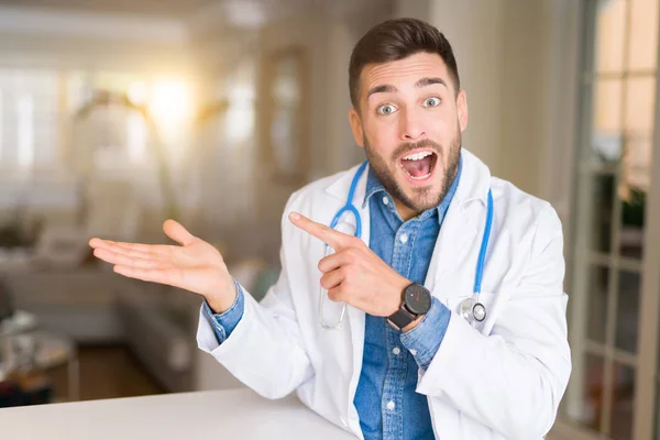 Молодий Красивий Лікар Людина Клініці Здивований Посміхається Камери Представляючи Рукою — стокове фото