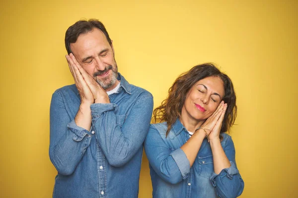 Belo Casal Meia Idade Juntos Sobre Fundo Amarelo Isolado Dormindo — Fotografia de Stock