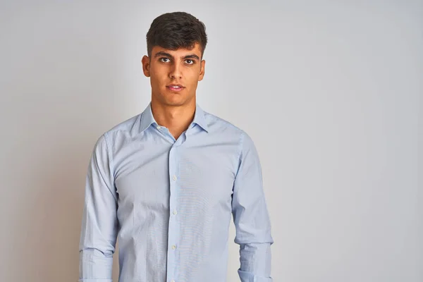 真剣な表情で孤立した白い背景の上に立つエレガントなシャツを着た若いインドのビジネスマン カメラを見てシンプルで自然な — ストック写真