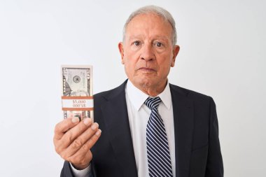 Üst düzey gri saçlı işadamı ciddi düşünme akıllı yüz üzerinde emin bir ifade ile izole beyaz arka plan üzerinde dolar tutan takım elbise giyiyor