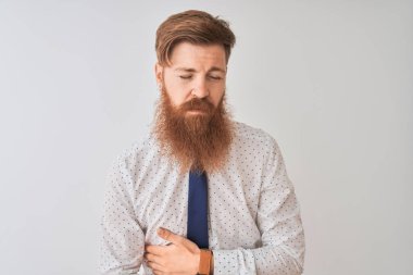 Genç Redhead İrlandalı iş adamı mide el ile izole beyaz arka plan üzerinde ayakta çünkü hazımsızlık, ağrılı hastalık duygusunu. Ağrı kavramı.
