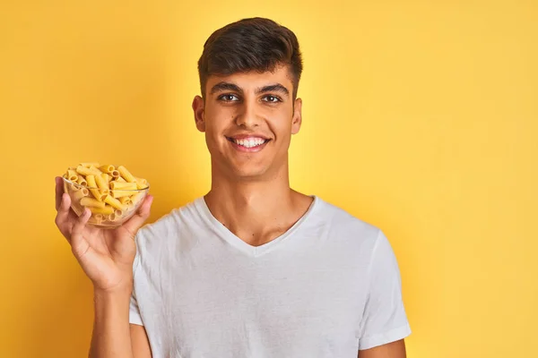 Young Indian Man Holding Bowl Dry Pasta Standing Isolated Yellow — Stock Photo, Image