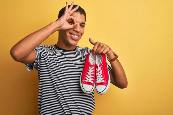 Joven Hombre Árabe Guapo Sosteniendo Zapatillas Informales Pie Sobre Fondo — Foto de Stock
