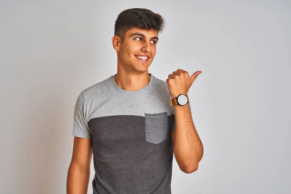 カジュアルなTシャツを着た若いインド人男性が 孤立した白い背景の上に立ち 幸せそうな顔で微笑み 親指を上げて横を向いている — ストック写真