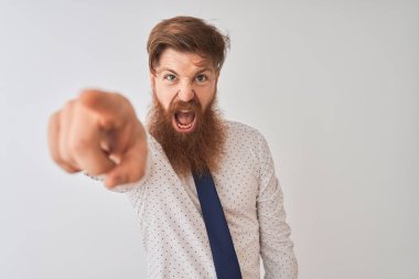 İzole beyaz arka plan üzerinde ayakta genç Redhead İrlandalı işadamı memnun ve kamera için sinirli, öfkeli ve öfkeli