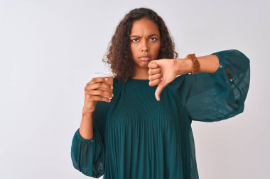 Genç Brezilyalı kadın alkol öfkeli yüz ile izole gri arka plan üzerinde ayakta kahve dikiliyor, negatif işareti başparmak aşağı ile sevmediğim gösteren, ret kavramı