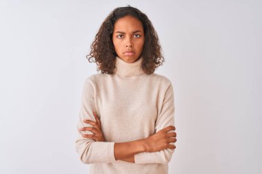 İzole beyaz arka plan üzerinde ayakta balıkçı yaka kazak giyen genç Brezilyalı kadın şüpheci ve sinir, Çapraz kollar ile yüz üzerinde ifade onaylamıyor. Negatif kişi.