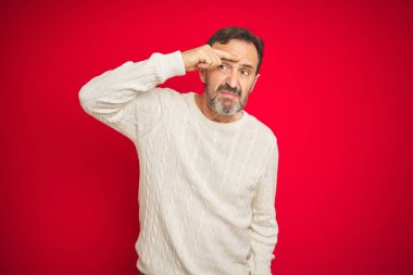İzole kırmızı arka plan üzerinde gri saçlı yakışıklı orta yaş kıdemli adam alnında sivilce için mutsuz işaret, siyah kafa çirkin enfeksiyon. Akne ve cilt sorunu
