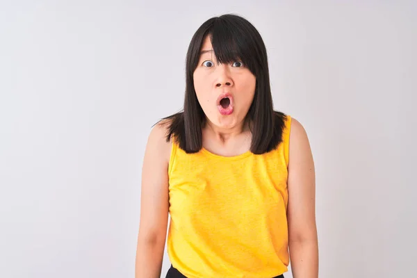 年轻美丽的中国女人穿着黄色T恤在孤立的白色背景害怕和震惊与惊喜的表情 恐惧和兴奋的脸 — 图库照片
