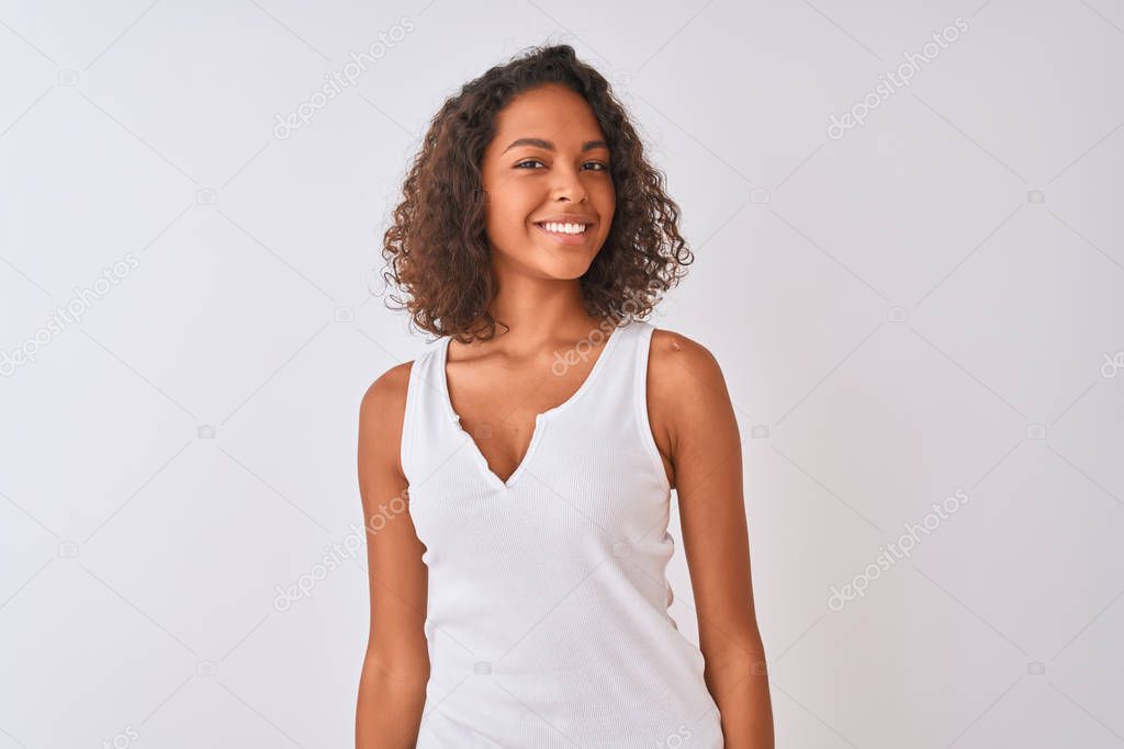 Young brazilian woman wearing casual t-shirt standing over isolated white background looking away to side with smile on face, natural expression. Laughing confident.