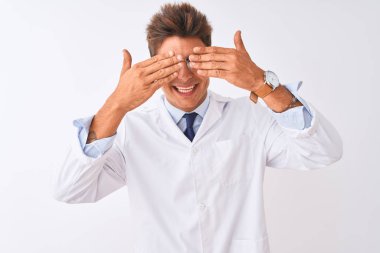 Genç yakışıklı sciencist adam gözlük ve ceket izole beyaz arka plan üzerinde elleri neşeli ve komik gülümseyen gözleri kapsayan giyiyor. Kör kavramı.