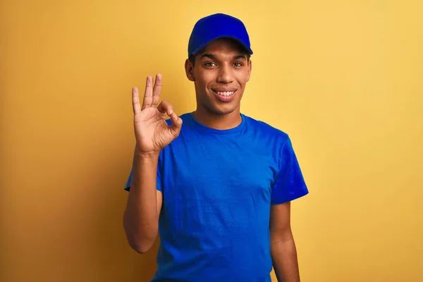 年轻的英俊的阿拉伯送货人站在孤立的黄色背景微笑积极做好标志与手和手指 成功的表达 — 图库照片