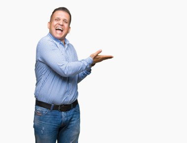 Orta yaş Arap iş adamı izole arka plan üzerinde el ve reklam mutlu ve kendinden emin gülümseyen sunulması avuç, yanında işaret