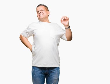 Orta yaş Arap adam wearig beyaz t-shirt izole arka plan germe üzerinde geri, yorgun ve rahat, Uykulu ve erken sabah esneme