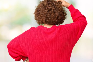 Güzel orta ager üst düzey kadın kırmızı kış kazak izole arka plan geriye düşünme hakkında şüphe kafasına el ile üzerinden