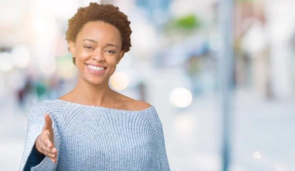 年轻美丽的非洲裔美国妇女穿着一件毛衣在孤立的背景微笑友好提供握手作为问候和欢迎 成功的业务 — 图库照片