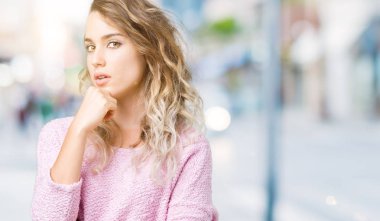 Güzel sarışın genç kadın emin çapraz kollar ve çeneme kaldırdı el ile gülümseme ile kameraya bakarak izole arka plan üzerinde. Pozitif düşünce.